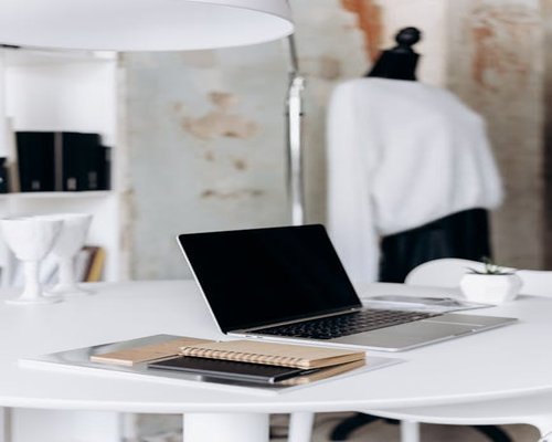 clean minimalist white office desk with laptop and notebook