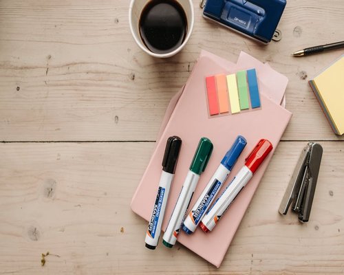 organized desk with stationery and coffee cup